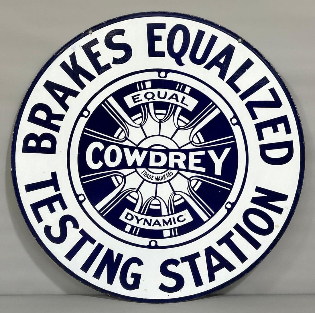 Cowdrey Brakes Equalized Testing Station w/Wood Spoke Logo Porcelain Sign (TAC): rated 8.75, 36"D., the DSP sign has very good color and gloss. Sign has a few tiny chips in both fields and light wear. Rarity 7. TAC #061337