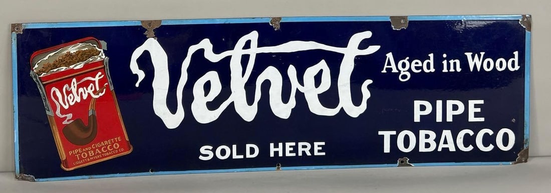 Velvet Pipe Tobacco Sold Here w/Image Porcelain Sign (TAC): rated 8.5, 11.75"x39", the SSP sign has good color and gloss, has wear in the field, chips around the perimeter and holes. Rarity 3. TAC #062744