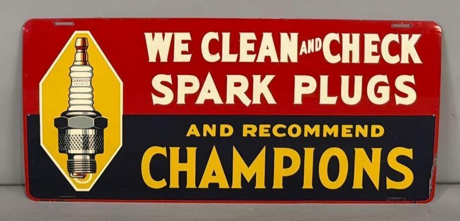 We Clean & Check Spark Plugs Champions w/Image Metal Sign (TAC): rated 9, 12"x26', the SST sign has very good color and shine, has light wear, has paint chips at right-hand edge, marked Made in U.S.A. Rarity 4. TAC #063765