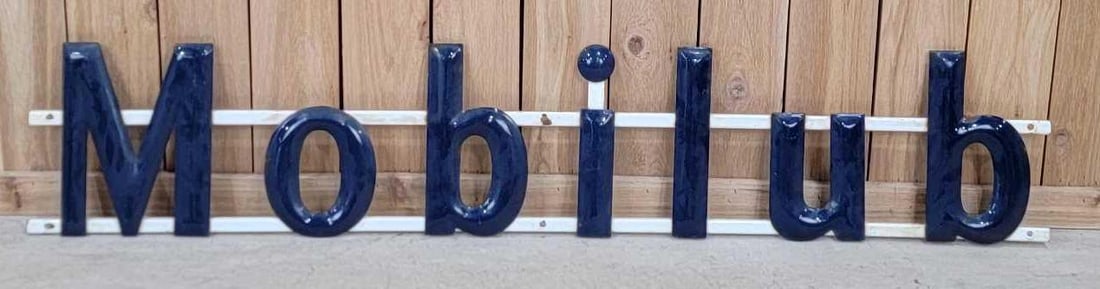 "Mobilub" Porcelain Sign W/ Porcelain Mounting Slats: (Rated 8.25). 12" x 64". This SSP sign has good color and gloss but is missing the "rication" section. Sign has good color and shine with porcelain loss and staining on the edge of the letters. Rarity
