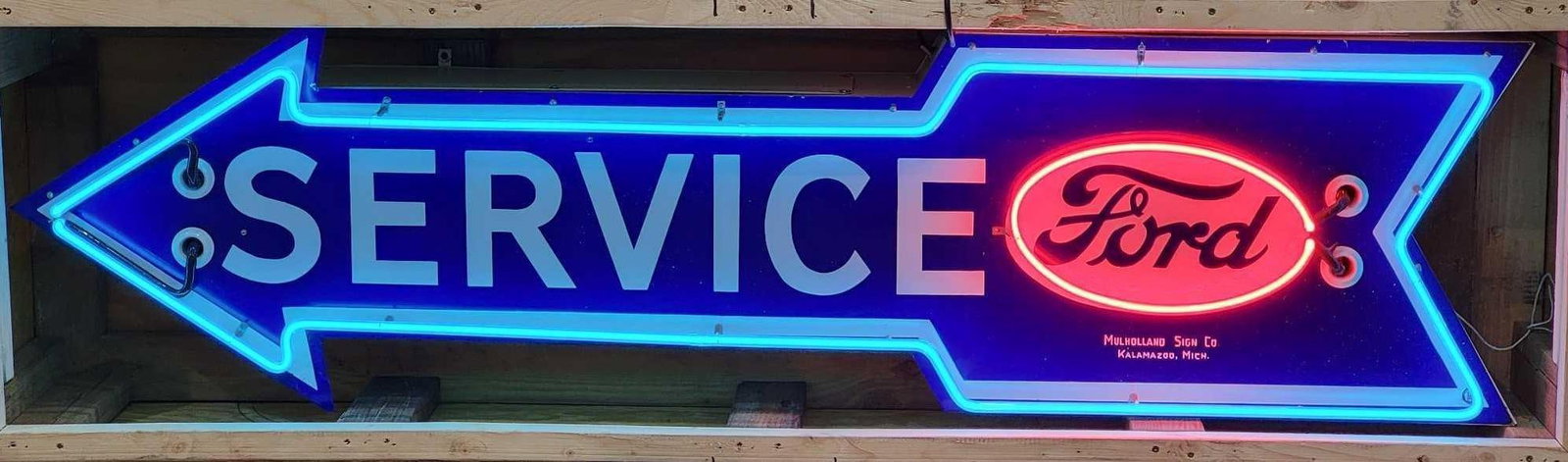 Ford Service Porcelain Neon Arrow Sign (TAC): rated 9, 18"x72", the SSP diecut neon sign has excellent color and gloss, field is clean, the bottom point of the arrow has been touched up, marked Mulholland Sign Co. Has been mounted on a new metal 
