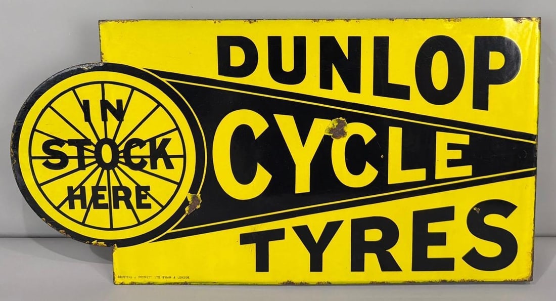 Dunlop Cycle Tyres "in Stock Here" Porcelain Flange Sign (TAC): rated 8.5, 14"x27", the diecut porcelain flange sign has very good color and gloss, both sides have a few dime size chips in the field, tiny chips around the perimeter, marked Griffiths. TAC #063646