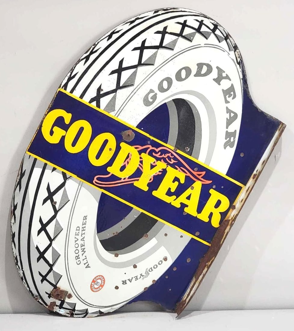 Goodyear Large Tire Porcelain Flange Sign (TAC): rated 7.75, 34"x21.75", the die-cut porcelain flange sign has good color and gloss, has chips in the field and around the perimeter, has one nail in the field and one at the bottom, chips on the flang