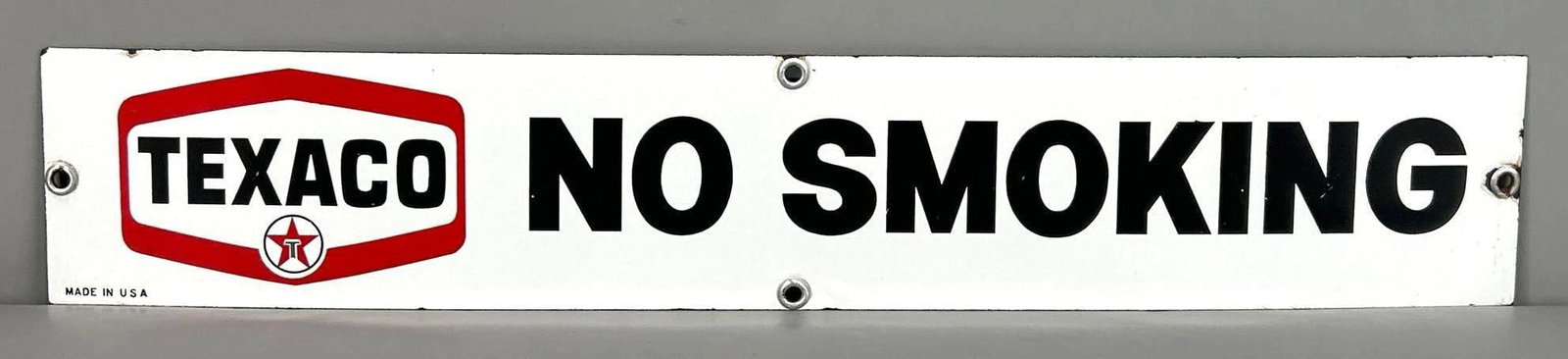 Texaco No Smoking Single-Sided Porcelain Sign: (Rated 8.9). 4" x 23". This SSP sign has good color and gloss throughout. Sign shows minor abrasions on the black lettering, as well as, porcelain loss and staining on the outer edge. Rarity 2. TAC #