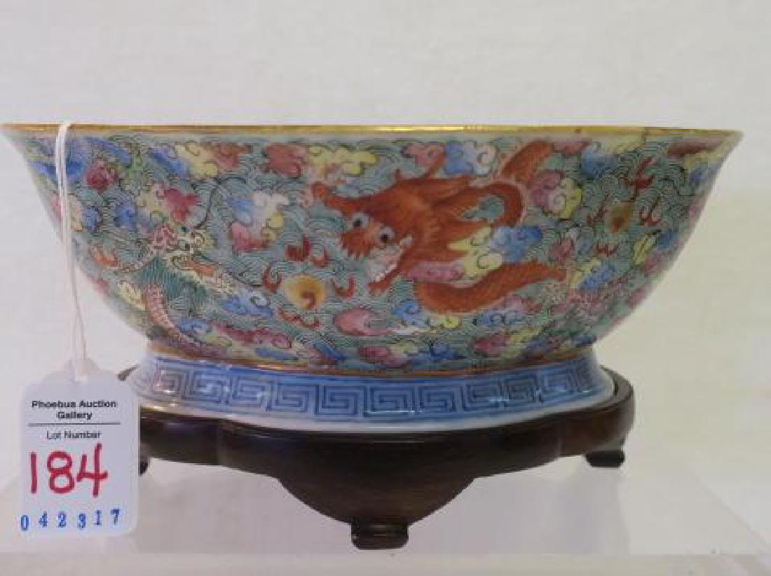 Chinese Export Lobed Bowl on Stand:: Chinese Export Lobed Bowl on Stand: Orange Peel Footed Bowl with Frolicking Dragons Amid Colorful Clouds. Greek Key Pattern on Foot. Mark on Bottom. 8 1/4" X 6 1/2". Custom Wooden Stand. (200-400)