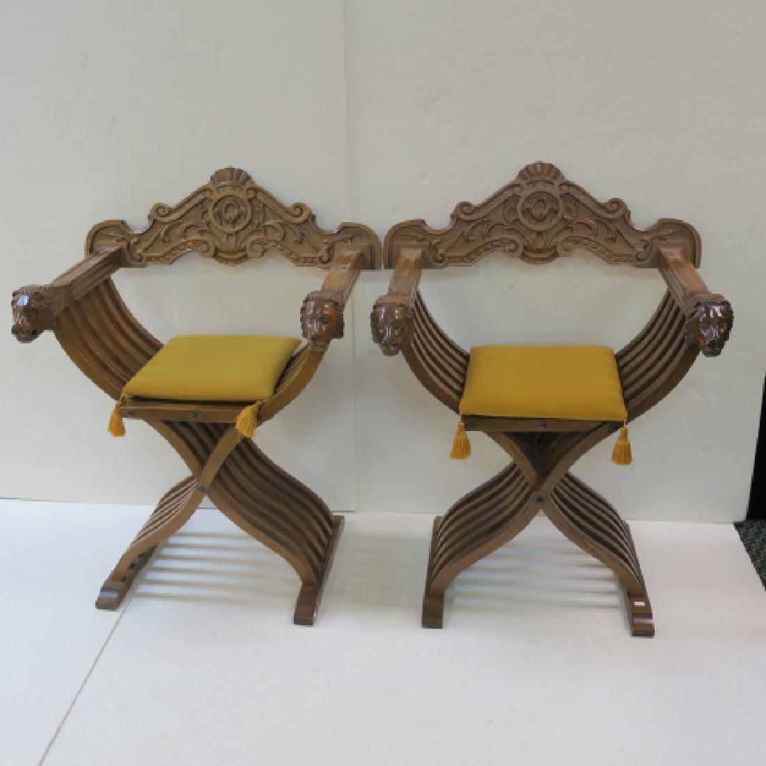Pair of Italian Renaissance Style Savonarola Chairs:: Pair of Italian Renaissance Style Savonarola Chairs: Walnut Arm Chairs with Slatted Frame and Hand Cut Cross Strut Legs. Scissor Frame Allows to be Folded. Hand Carved Back with Bas Relief Acanthus Le