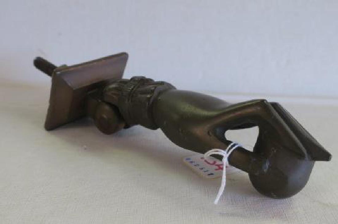 Victorian Cast Bronze Lady's Hand Door Knocker:: Victorian Cast Bronze Lady's Hand Door Knocker: Lady's Hand Holds a Ball with Ring on Finger and Cuff. Rectangular Back Plate. Hand is 5 3/4"L. (100-200)