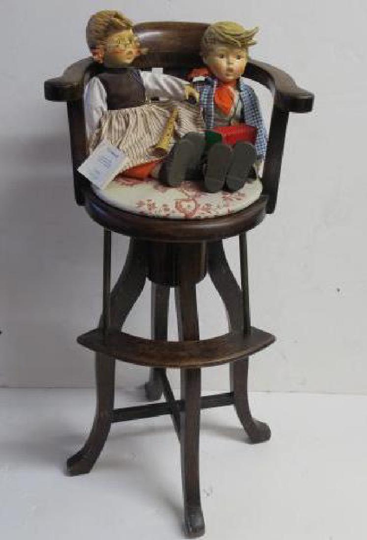 Two HUMMEL/GOEBEL Dolls and Vintage High Chair:: Two HUMMEL/GOEBEL Dolls and Vintage High Chair: Birthday Serenade Boy and Girl Dolls with Porcelain Heads and Limbs. Girl has Wooden Flute and Boy has Accordion. Certificates and Pendants Attached. 15