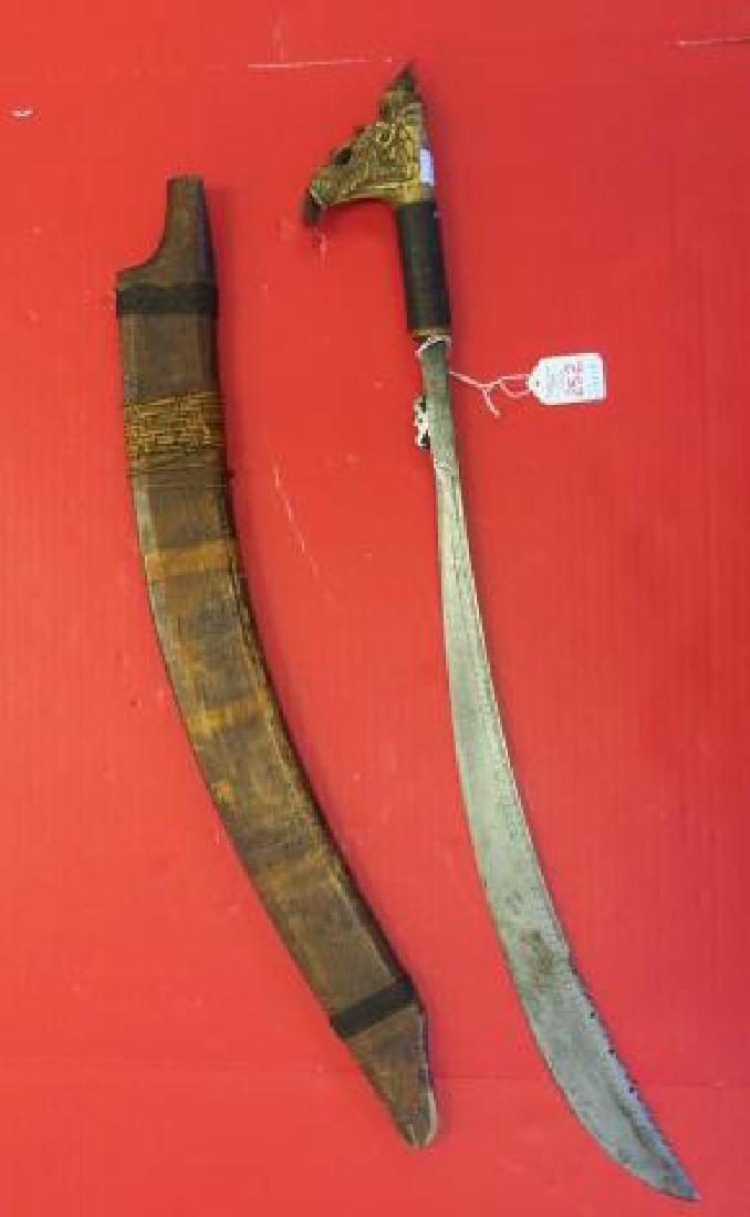 Antique African Sword with Mythical Beast Pommel:: Antique African Sword with Mythical Beast Pommel: Mystical Beast with Carving and Tufted Hair over Wrapped handle. Long Thin Engraved Chopper Style 20" Blade. No Hilt. Carved Wooden Scabbard with Natu