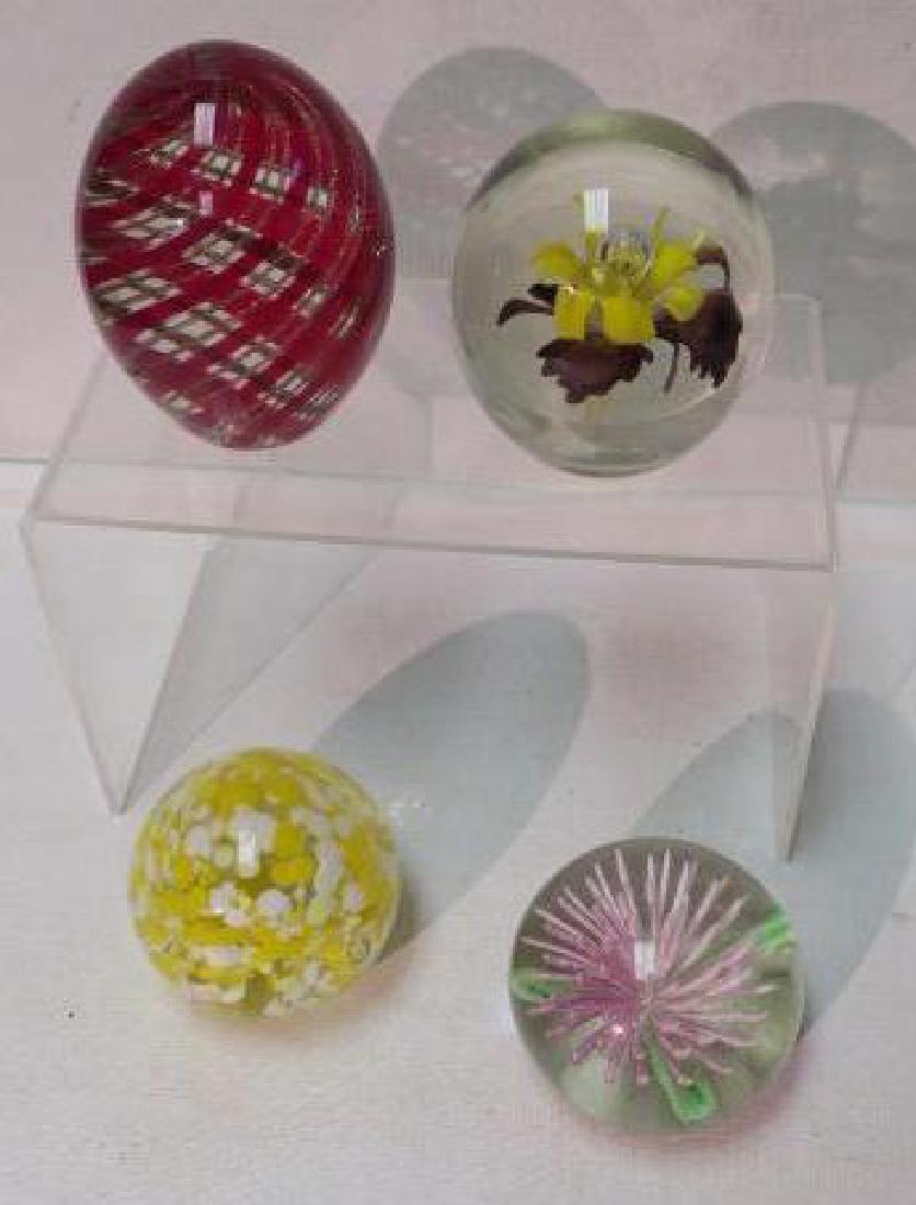 Four Art Glass Paperweights:: Four Art Glass Paperweights: 2 1/4" Egg Shaped Red and Gold Swirl, 2 3/4" Yellow and Purple Iris Flower with Rising Bubble, 2 1/2" Yellow and White Pastel Marked Globe, and 2 1/2" Pink Flower with whi