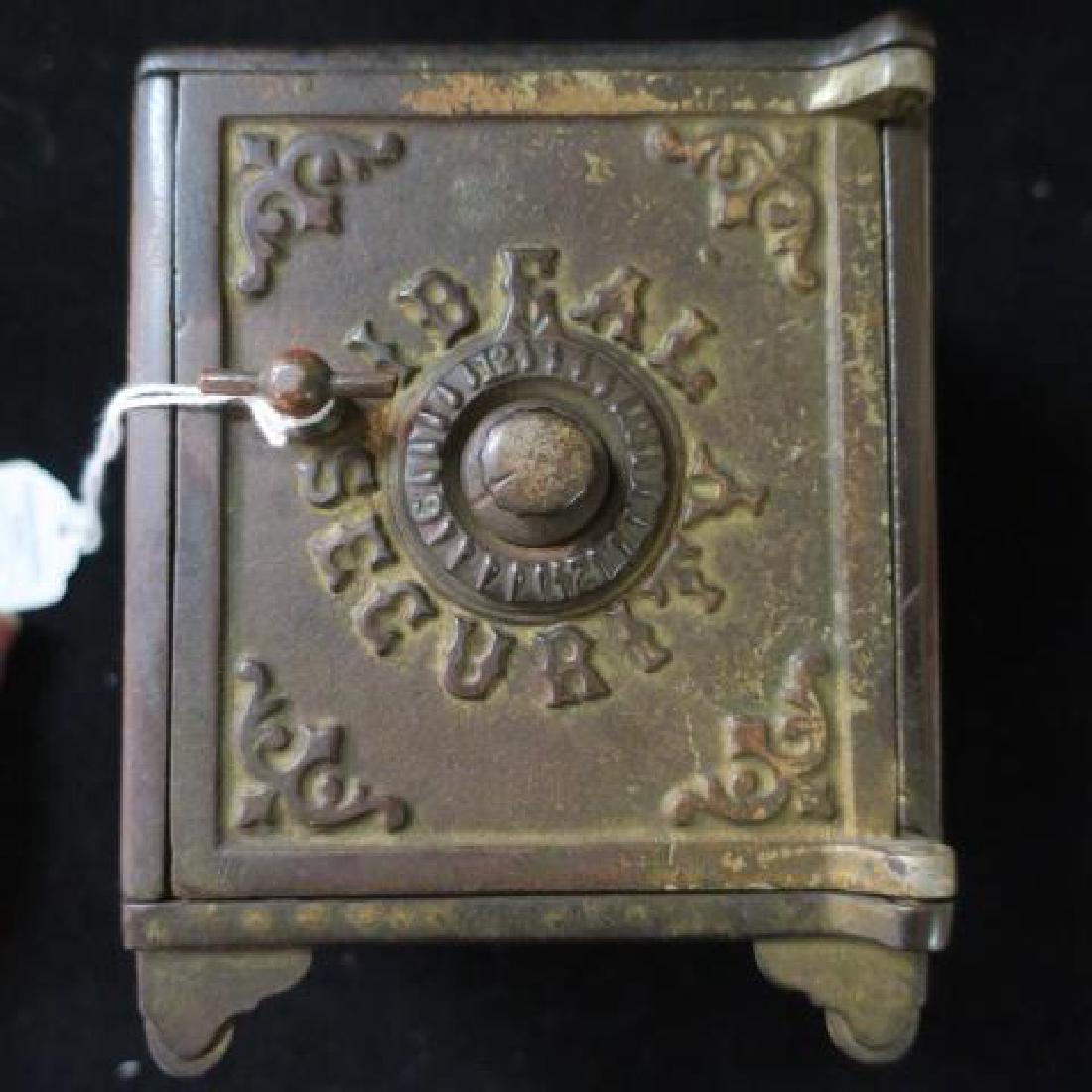 Antique Cast Iron "IDEAL SECURITY" Safe Style Bank:: Antique Cast Iron "IDEAL SECURITY" Safe Style Bank: Filigree Corners Decorate Bank Sides and Top of 5 1/2" Tall, 4 1/4" Wide, 3 7/8" Deep Bank. Combination Style Lock on door. (-)