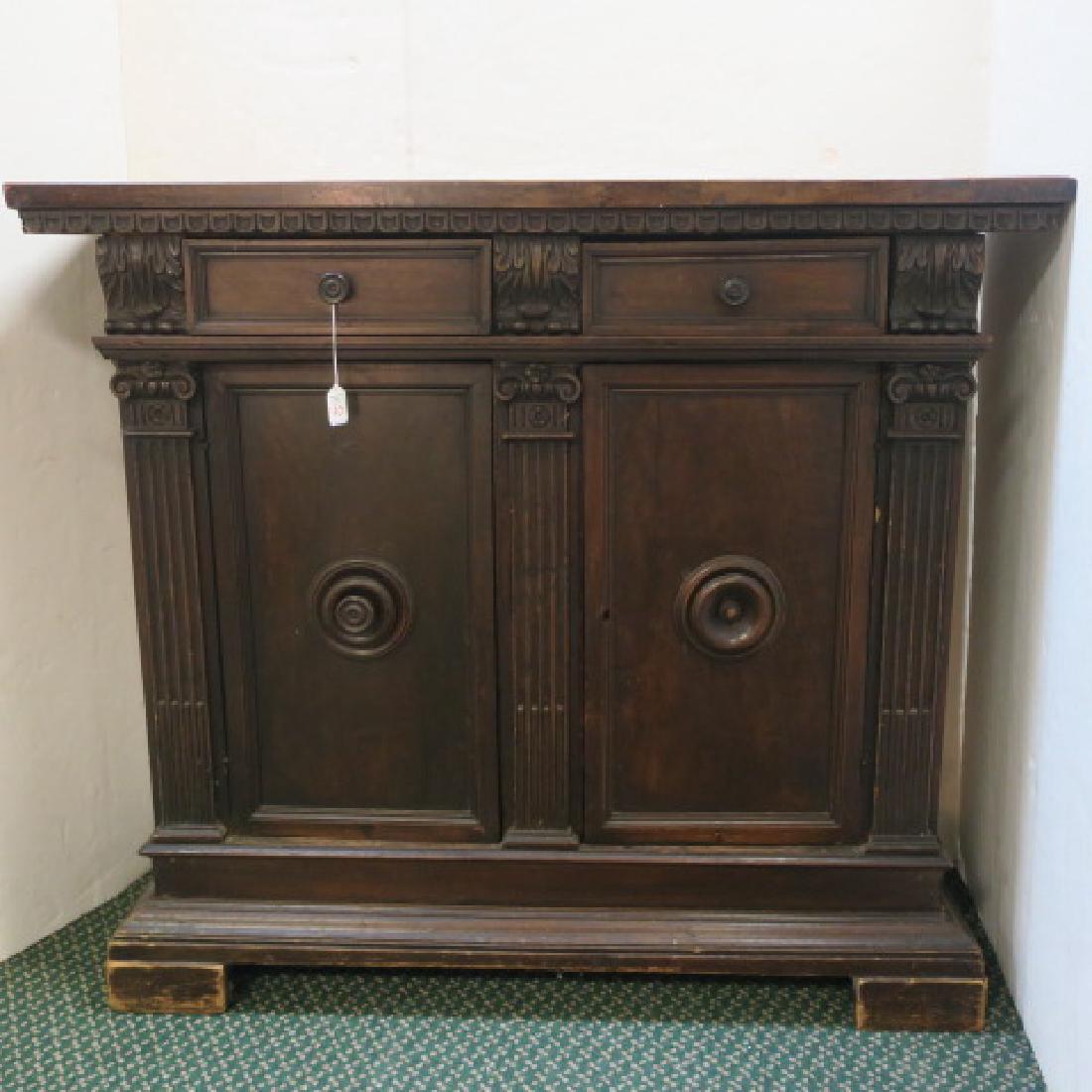 18th C. Walnut Server:: 18th C. Walnut Server: Flat Top over Scalloped Edge. Two Side by Side Drawers with Foliate Carving at Sides & Center. Double Blind Cabinets Below with Bullseye Centers. 1 Knob Absent. Grooved Columns 