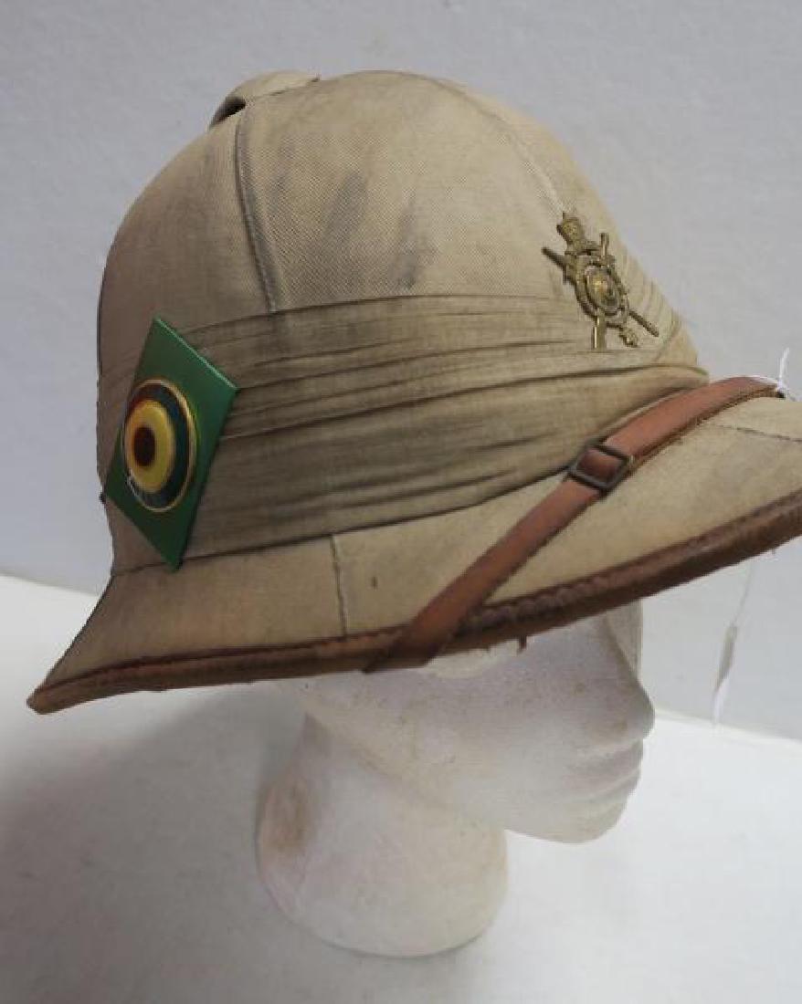 English Style Cavalry Summer Khaki Pith Helmet:: English Style Cavalry Summer Khaki Pith Helmet: Unit Crest with Arabic Lettering, Side Rondel in Red, White and Green on Square Diagonal. 10" x 13" x 11". Soiled (200-500)