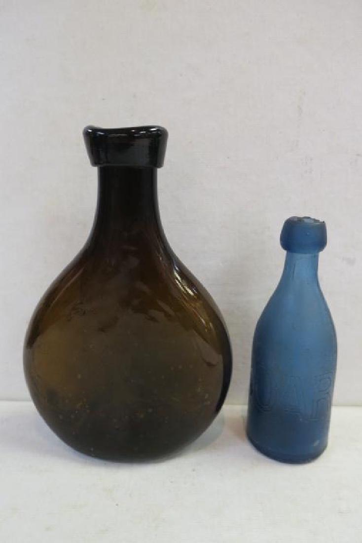 Two Antique Blown Glass Bottles:: Two Antique Blown Glass Bottles: Late 1700's to 1840 Amber Spirits Bottle. Rounded Flat Bottle has Lapped Ribbon Mouth and Open Rough Pontil. 9 1/2"T. Rare Cobalt Blue Mineral/Soda/Water Bottle. 1850'