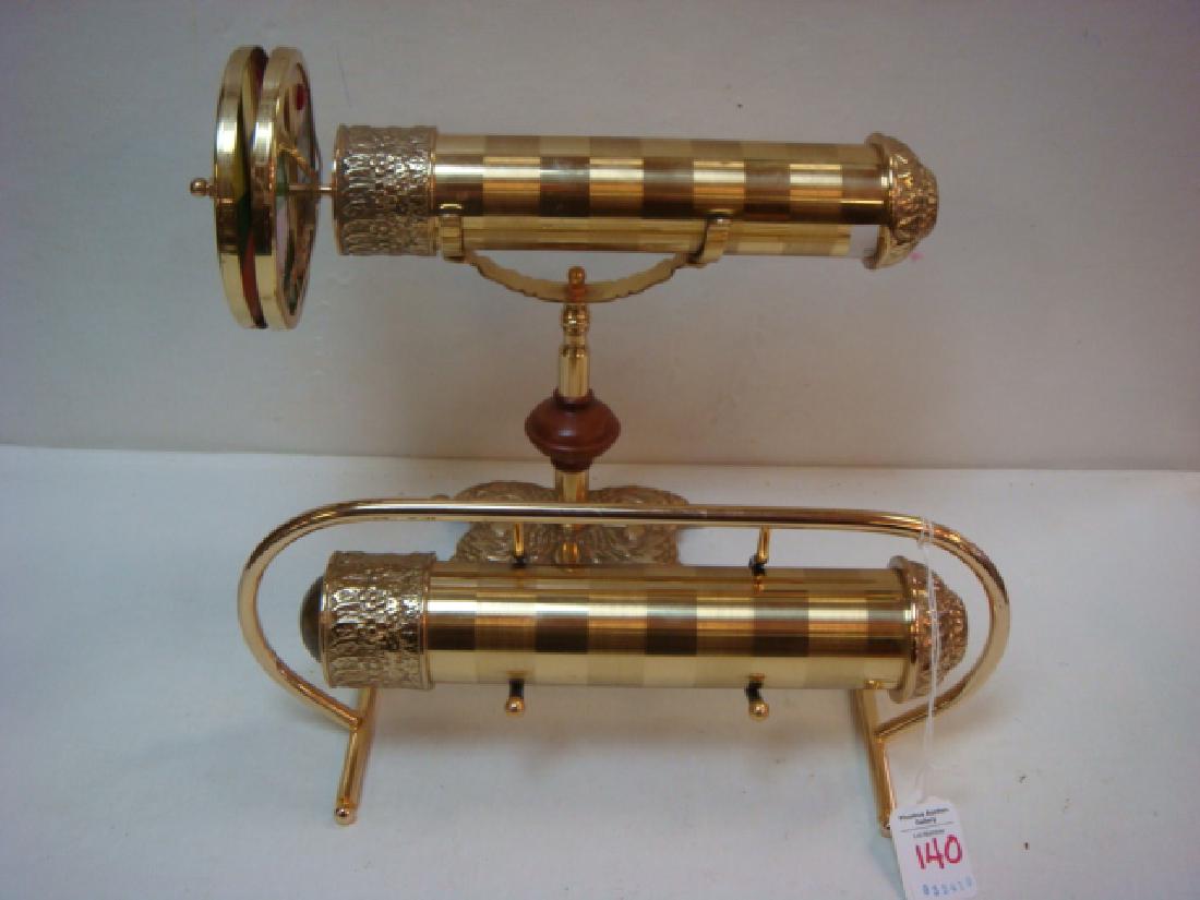 Two Brass Kaleidoscopes on Stands:: Two Brass Kaleidoscopes on Stands: 11 3/4"L Kaleidoscope has 2 Spinning Disks with Glass and 2 Jewels on End. Set on 7 3/4"T Brass and Wooden Stand. 10"L Kaleidoscope with Bullseye Lens Set on 5"T, 12