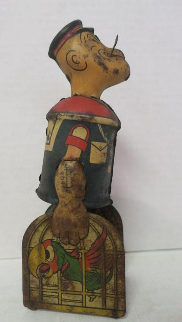MARX Tin Litho Popeye Wind Up Toy with Parrots:: MARX Tin Litho Popeye Wind Up Toy with Parrots: Popeye Carrying Parrot Cages, In Working Condition. Original Paint and Pipe. Some Surface Rust Throughout Consistent with Age and Use. 8 1/4"T. (150-250