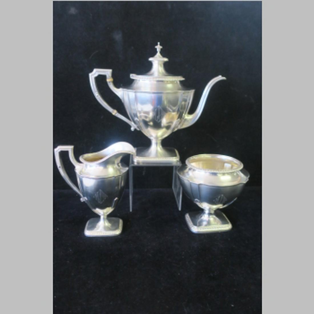 REED & BARTON Three Piece Sterling Tea Set:: REED & BARTON Three Piece Sterling Tea Set: St. George Pattern. Pedestal Bases, Ribbed Edge. 9"T Teapot, 6 1/4"T Creamer and 5"T Open Sugar Bowl. 49.13 oz. or 41.42 ozt.. (800-1000)