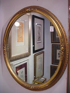 Oval Gilt Carved Floral Framed Mirror: Oval Gilt Carved Floral Framed Mirror: 24" X 28 1/2" Wood Carved Gold Framed Mirror with Apples and Floral Garland. Gadrooned Edges. (60-100)