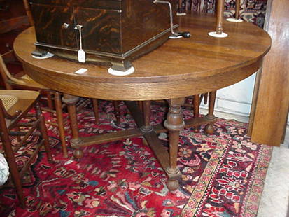 Round Oak Table with 4 Leaves: Round Oak Table with 4 Leaves: Darkened Oak, 47 1/2"D X 29"T, with Four 7" Leaves. Bell Turned Legs and X Stretcher, Ball Feet on Wooden Castors. (300-500)