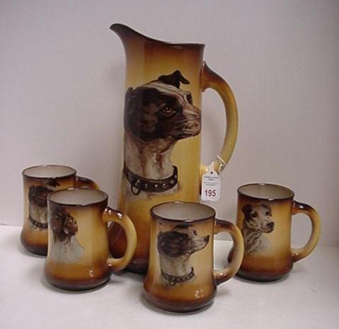 Taylor, Smith & Taylor Tankard and Mug Set: Taylor, Smith & Taylor Tankard and Mug Set: 13 1/2"T. Tankard had Greyhound Transfer. Four Matching 4 3/4"T. Mugs has Greyhound and Other Dog Transfers. Some Crazing, One Mug has Fracture.