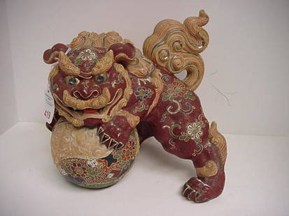 Hand Painted Ceramic Foo Dog Statue on Ball: Hand Painted Ceramic Foo Dog Statue on Ball: Metal Accent Insets on Burgundy Dog with Floral Decorations. 10"T with Repaired Tail.