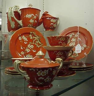 20 Piece Noritake China and Serving Pieces: 20 Piece Noritake China and Serving Pieces: Floral Branch on Burnt Orange Ground. Includes 4 Cups, 6 Saucers, Sugar, Creamer, Teapot and Five 7 1/2"D Plates. Chip on Sugar.