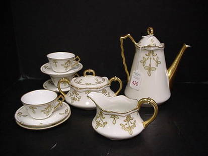 9 Piece Limoges B & H Tea Set: 9 Piece Limoges B & H Tea Set: White Ground with Gold Trim and Sprigs of Green Leaves. Includes Sugar with Lid, Creamer, Teapot with Lid, 3 Cups and Saucers.