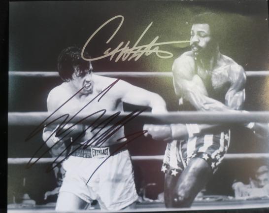 SYLVESTER STALLONE & CARL WEATHERS Autographed B&W:: SYLVESTER STALLONE & CARL WEATHERS Autographed B&W: Photograph from Rocky of the Classic Fight-the First Rocky Film. (100-200)