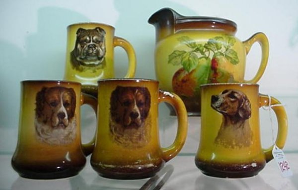 5 Piece TAYLOR SMITH and TAYLOR Mugs and Pitcher: 1242. 5 Piece TAYLOR SMITH and TAYLOR Mugs and Pitcher: 7"T Pitcher with Pear Transfer. Crazing on Interior. 4 Dog Transfer Mugs are 5"T. Some Glaze Wear.