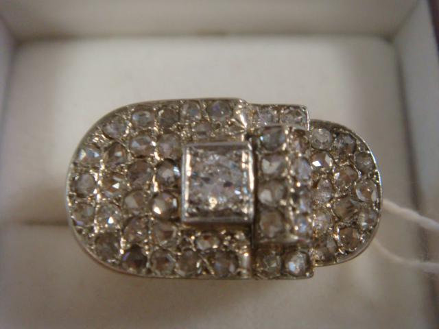 14K Gold and Diamond Buckle Ring:: 14K Gold and Diamond Buckle Ring: 1/2 Ct Center Diamond in Oval Buckle Setting Surrounded by 50 Small Diamonds. Size 1 1/2 with Added Gold Sizing Beads. Total Weight .318 oz. or 9.03 Grams. (600-1200)