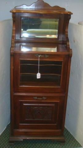 Mahogany 3 Tier Music Cabinet:: Mahogany 3 Tier Music Cabinet: Shaped Beveled Top Shelf Over Beveled Mirror. Two Pull Down Doors, Top with Glass Front Opening to Shelved Interior and Bottom with Carved Front to Hold Music Sheets. Br