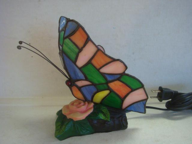 Colorful Slag Glass Butterfly Lamp:: Colorful Slag Glass Butterfly Lamp: Subtle Glow from Single Bulb through Multicolored Rounded Wings with Copper Foil Wing Veins, Red Cabachon Eyes and Wire Antenna. Set on Resin Base of Single Rose on