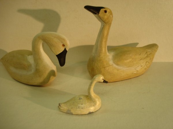 3 Handcarved and Painted Wooden and Lead Swans: 264. 3 Handcarved and Painted Wooden and Lead Swans: 3 1/2"L Metal Swan is 2 1/2"T, Some Paint Flakes. 9"L is Unsigned and Missing 1 Glass Eye. 8 1/2"L, 6 1/2"T with Upturned Head Appears to be by Sam