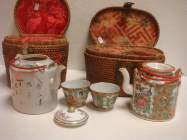 Two Chinese Export Teapots in Baskets:: Two Chinese Export Teapots in Baskets: Rose Medallion Traveling Teapot and Cups in Fitted Warming Woven Basket. Lidded Teapot has Wrapped Wire Handles. 4"T. Old Repair to Rim. 2 Cups are 2"T. Basket w