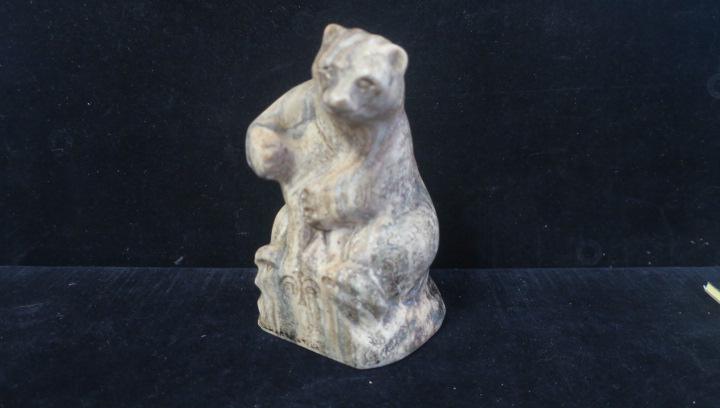 Carved Stone Bear:: Carved Stone Bear: Carved from a Striated Stone, the Bear Appears to be Hugging a Tree Stump. Carved Design on Front. 6 1/4"T. (200-400)