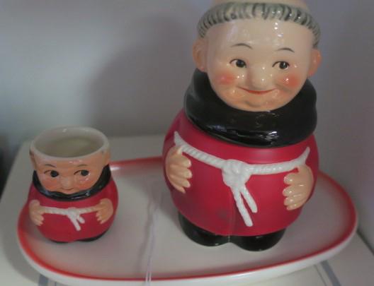 GOEBEL, FRIAR TUCK CIGARETTE URN and SNUFFER on TRAY:: GOEBEL, FRIAR TUCK CIGARETTE URN and SNUFFER on TRAY: In Red Color with Pink Rim on Tray. Urn is 4" Tall. In Original Packaging. (50-100)