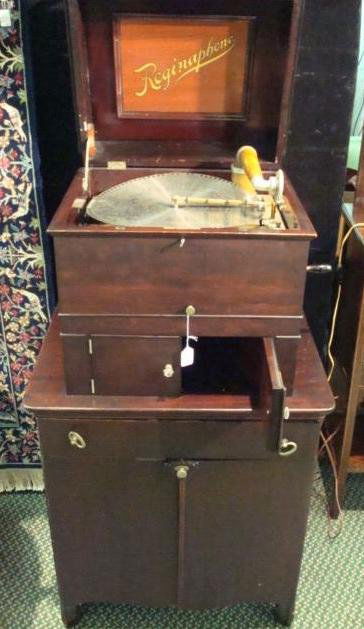 REGINAPHONE Mahogany Console Phonograph/Music Box: REGINAPHONE Mahogany Console Phonograph/Music Box: Upright Mahogany Case with Lift Lid, Tone Arm, Turntable. Two Center Doors Open for Horn, Lower Doors for Record and Disc Storage. Includes 25 Discs,