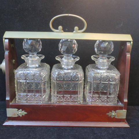 Victorian Cut Crystal Tantalus:: Victorian Cut Crystal Tantalus: Three Square Cut Crystal 9" Decanters with Faceted Stoppers. Mahagany Stand with Brassed Metal Corner Braces and Locking Top (No Key). 11 1/2" x 13 1/2" x 5" ($300-$500