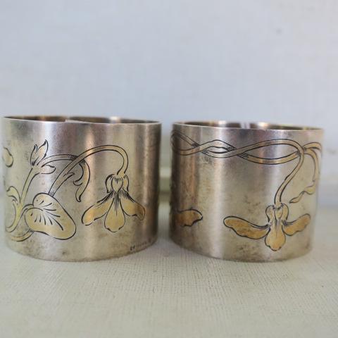 Two German 800 Silver Wilhelm Muller Napkin Rings:: Two German 800 Silver Wilhelm Muller Napkin Rings: Maker Active First half of 20th C. Pair of Napkin Rings Each with Engraved Gold Florals. 1 1/2"W, 2"D. (60-120)
