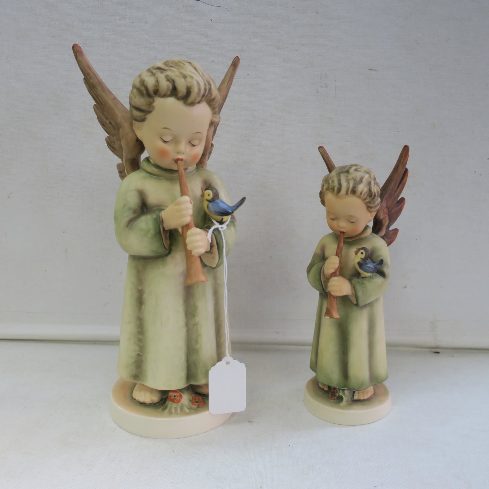 HUMMEL "Festival Harmony" 8" & 11"T Figurines:: HUMMEL "Festival Harmony" 8" & 11"T Figurines: HUM 173/II Angel with Flute, TMK-5 is 11"T. Flowers Between Feet and Textured Gown. HUM 173/0, TMK-4 is 8"T. (150-300)