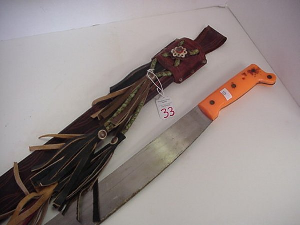 Long Machete With Leather Decorated Scabb: Long Machete With Leather Decorated Scabbard Modern Orange Handled Machete. 33 1/2" Long with Leather Embossed and Tassel Decorated Scabbard.