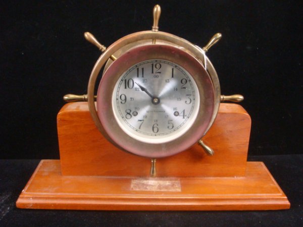 Ship's Wheel SETH THOMAS Helmsman Shelf Clock: Ship's Wheel SETH THOMAS Helmsman Shelf Clock: Wooden Base is 13 3/4" X 4 1/4". 10"T. Marked on Back Cat# 1052, Model# 1052-001. Seth Thomas by Talley Industries. Missing One Handle. (60-100)