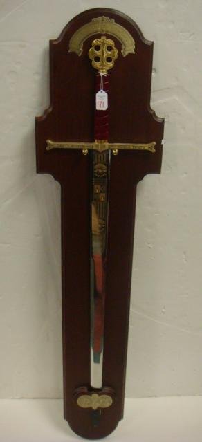 Fantasy "SWORD OF COLUMBUS" Tanto Monta:: Fantasy "SWORD OF COLUMBUS" Tanto Monta: Broadsword with 38" Blade and Cross Hilt Decorated with "TANTO MONTA MONTA TANTO". 48" LOA. With Wooden mounting plaque 53" x 13". Very Good Condition. (100-35