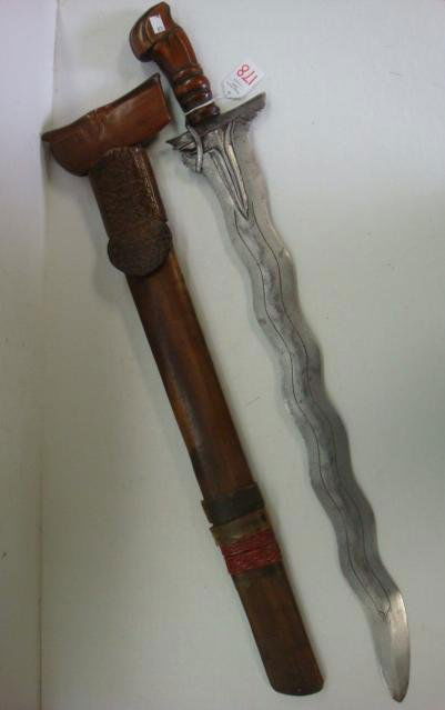 Malay KRIS SWORD with Wooden Scabbard: Malay KRIS SWORD with Wooden Scabbard: Distinctive Curving Engraved Blade with Asymmetrical Spur at Base of Blade. Carved Wooden Handle. 24" Blade and 29 1/2" LOA. Wooden Scabbard with Leather Embosse
