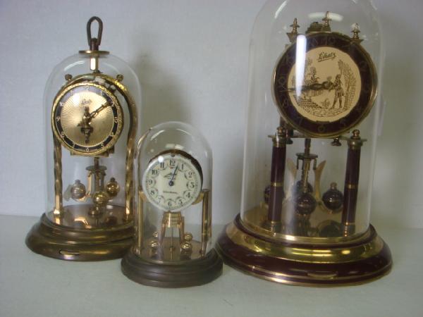 2 SCHATZ and CONTESSA German Anniversary Clocks:: 2 SCHATZ and CONTESSA German Anniversary Clocks: 10 1/4"T Schatz has Couple in Gold on Dial. Plastic Dome. 10"T Schatz with Glass Dome. No Keys. 4 3/4"T Contessa Wind-Up Clock with Glass Dome Needs Wo