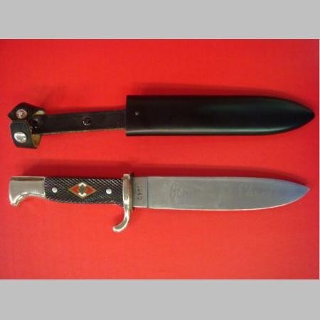 Hitler Jungen Belt Knife: Hitler Jungen Belt Knife: Hitler Jugen Belt Knife with Logo on Checkered Grips. Marked with "Blut und Ehre!" on Blade Also Marked "1940". With Metal Scabbard and Leather Carrier. 5 1/2" Blade. (100-25