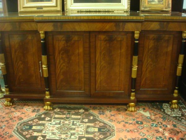 BAKER FURNITURE CO Breakfront Credenza: BAKER FURNITURE CO Breakfront Credenza: Shaped Top with Custom Fitted Glass. 4 Doors Framed in Black and Gilt Columns Ending in Stylized Paw Feet. Adjustable Shelves Behind Each Door. 36"T, 72"W, 17 1