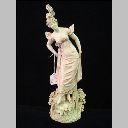 RStK Amphora Porcelain Female Figurine, Ca 1899-19: RStK Amphora Porcelain Female Figurine, Ca 1899-1905: 15 3/4"T Porcelain Figurine of Woman in Period Dress, Standing on Plinth with Tree Trunk and Flowers. Pastel Colors. Made by Riessner, Stellmacher