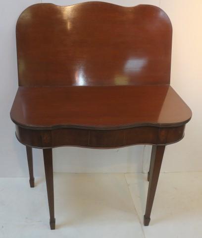 Inlaid Mahogany Hepplewhite Style Game Table:: Inlaid Mahogany Hepplewhite Style Game Table: Serpentine Front, Top Turns to Open to Flat Gaming Surface. Single Line Inlaid Drawer for Game Pieces. Raised on Square Tapered Legs, Spade Feet. Oval Flo