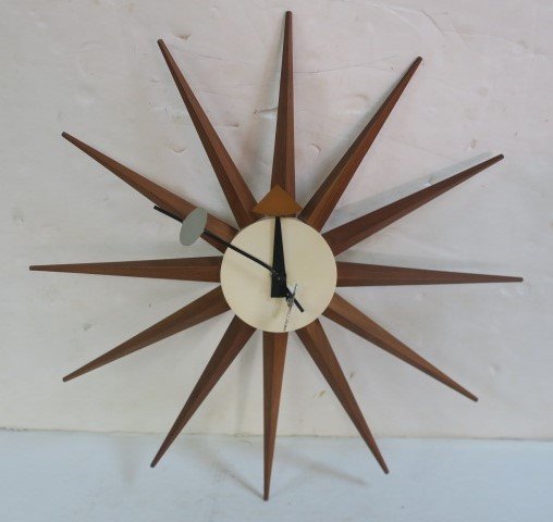 HOWARD MILLER SUNBURST CLOCK by GEORGE NELSON:: HOWARD MILLER SUNBURST CLOCK by GEORGE NELSON: Marked on Reverse ZEELAND MICH MODEL 2202. Cream Face with Walnut Spikes having all Their Points Sheet Metal Hands CA Late 1960's 19" Diameter, Keywind w